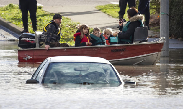 A woman and children who were stranded by high water due to flooding are rescued by a volunteer ope...