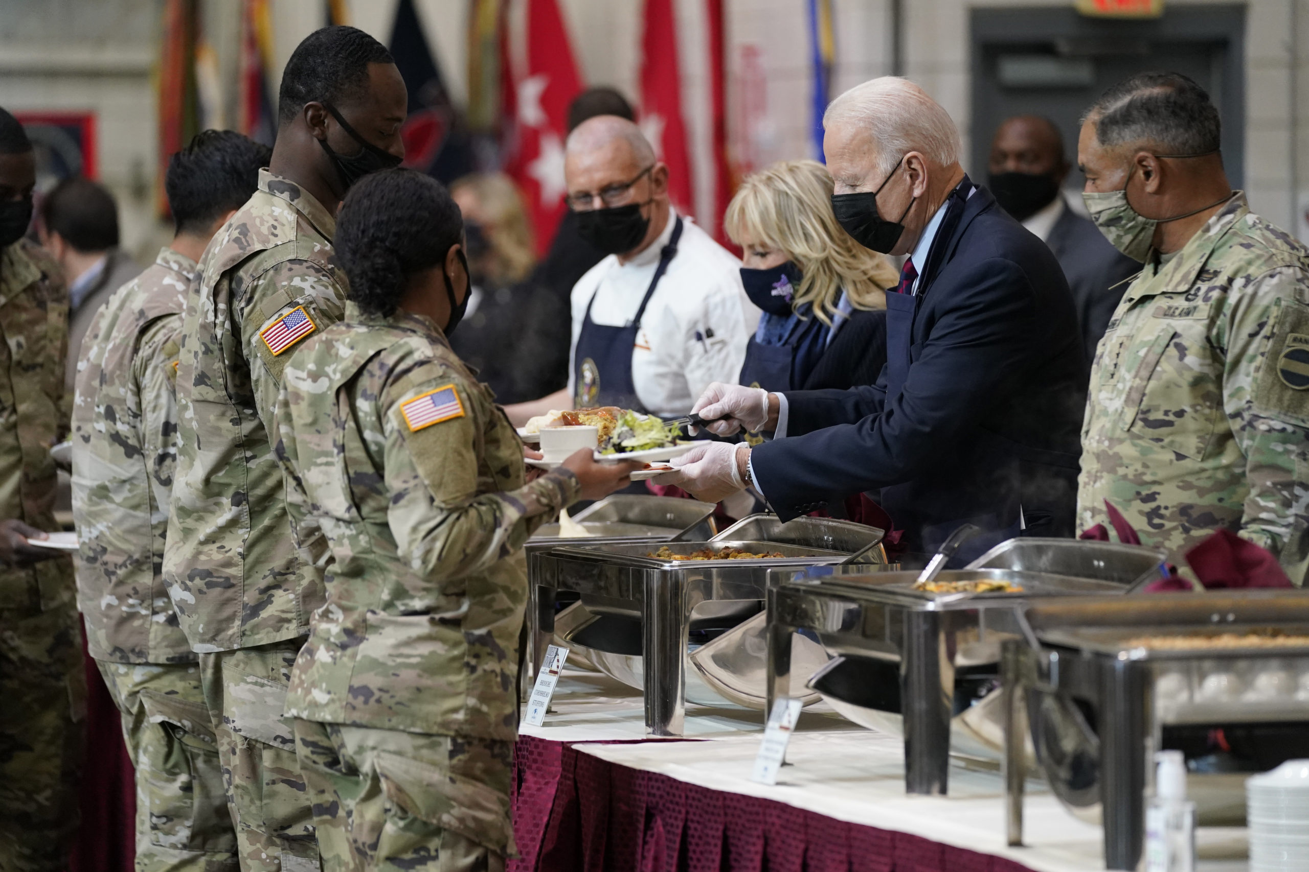 President Joe Biden and first lady Jill Biden serve dinner during a visit to Fort Bragg to mark the...