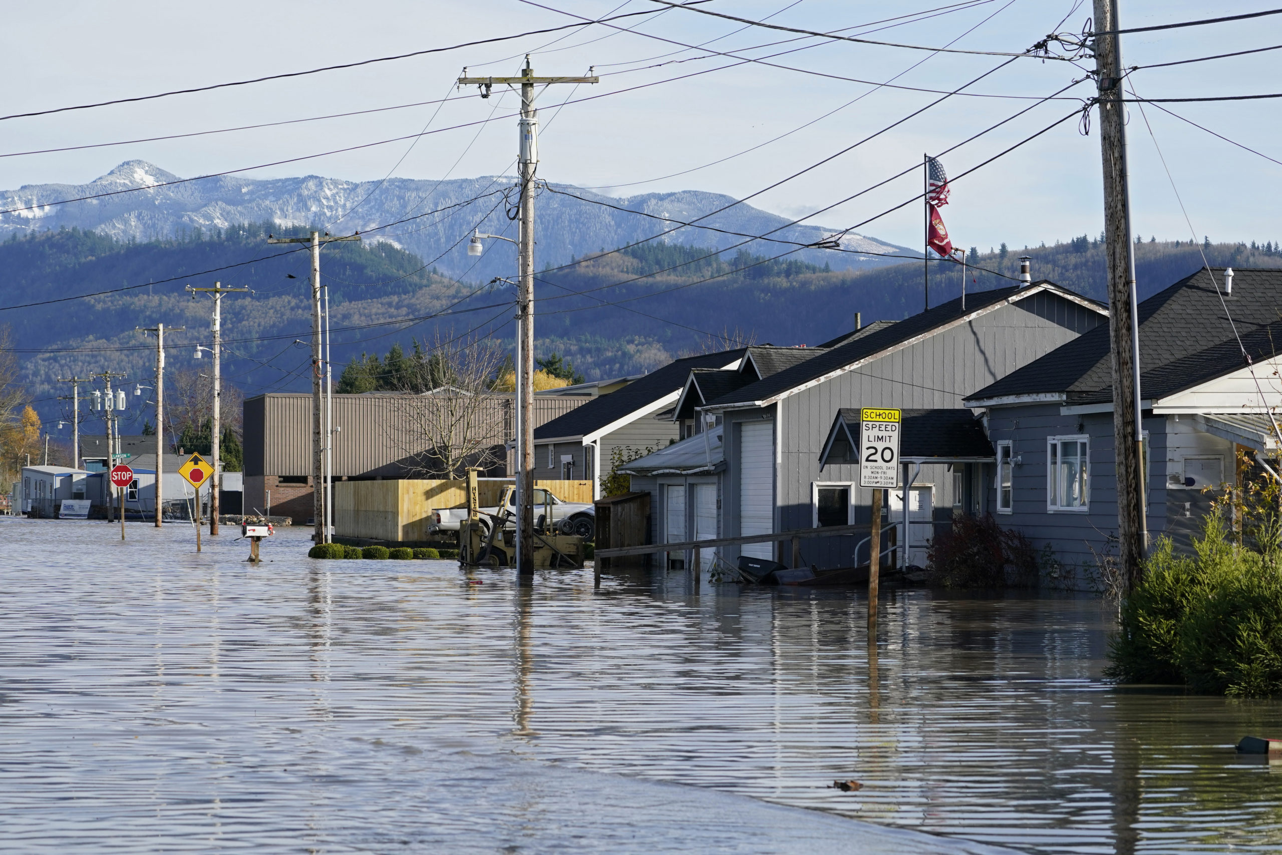 FILE - Floodwater inundates homes along a road on Nov. 17, 2021, in Sumas, Wash. Damages from flood...
