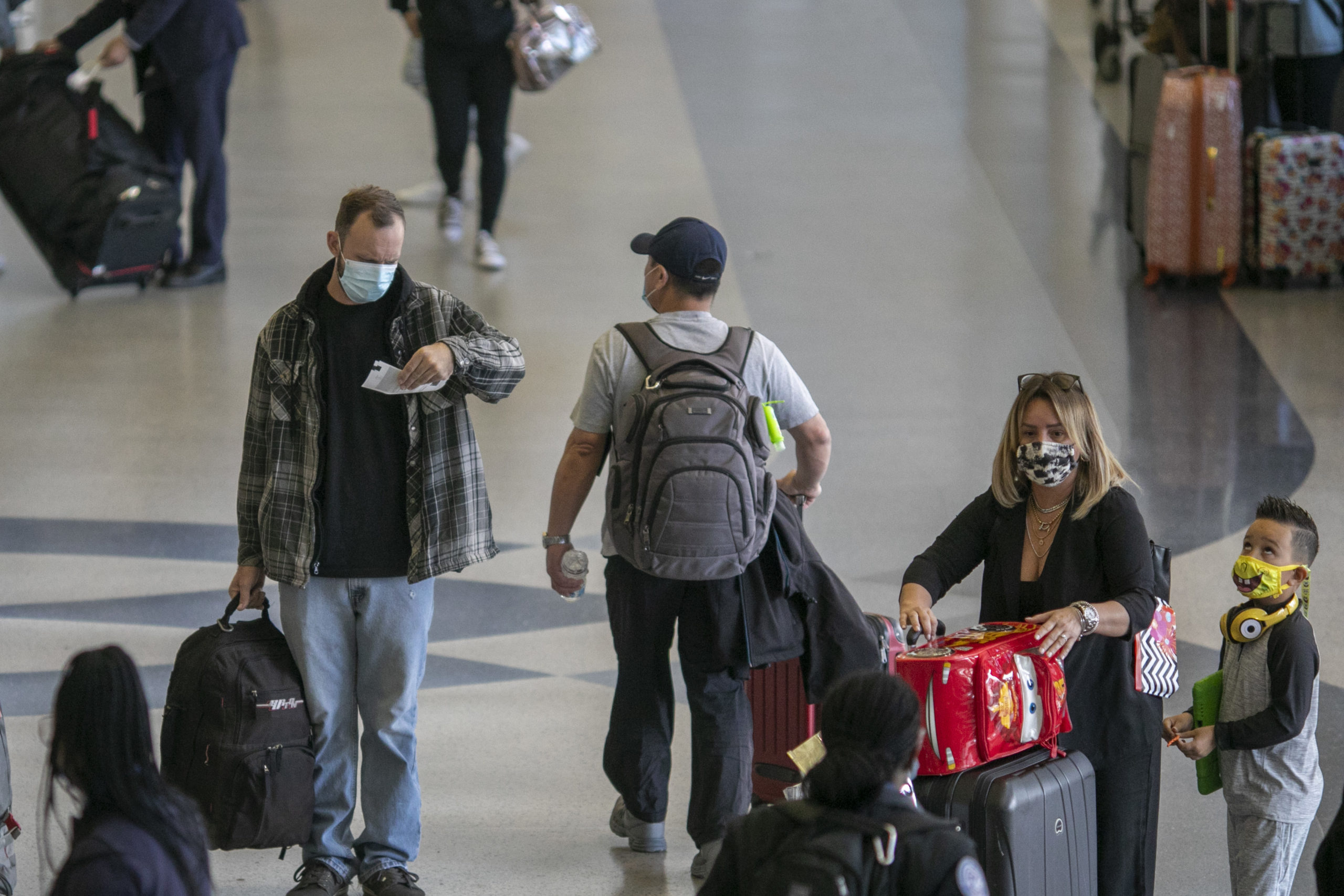 Holiday travelers pass through Los Angeles International Airport in November of 2020. Air travel is...