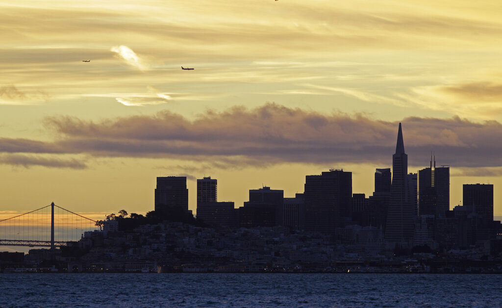Planes fly over the San Francisco skyline at dawn in this view from Sausalito, Calif., Tuesday, Dec...