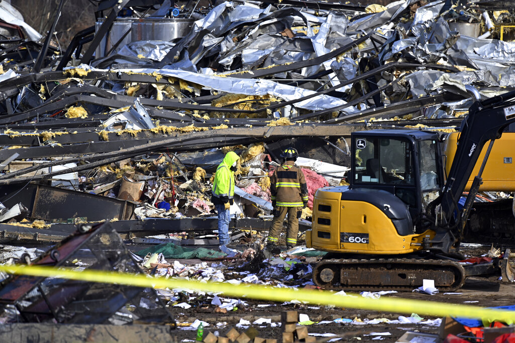 Emergency response workers dig through the rubble of the Mayfield Consumer Products candle factory ...