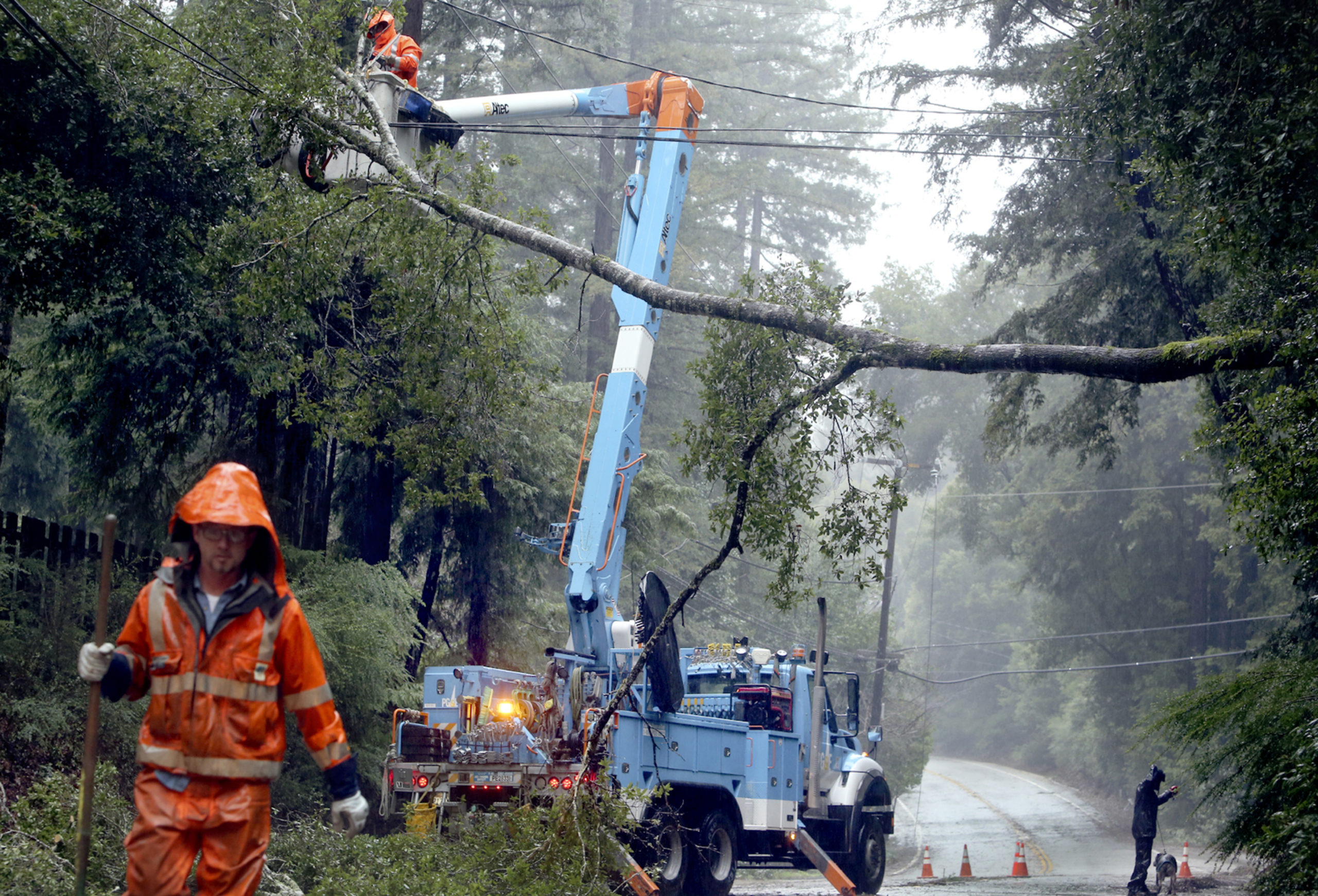 FILE - Pacific Gas & Electric crews work to clear a downed tree over Highway 9 north of Boulder...