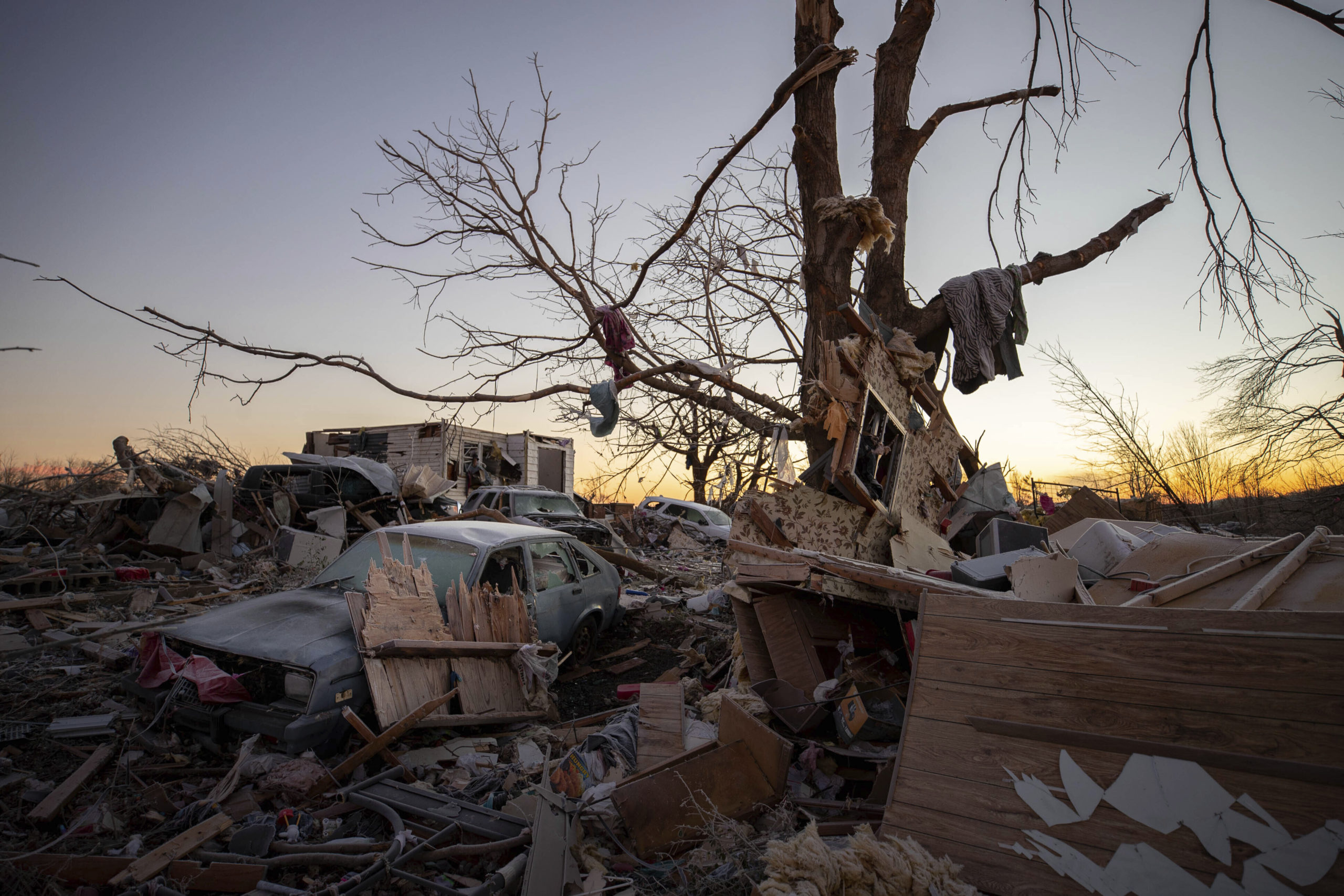 A car sits among the remains of a destroyed house after a tornado in Dawson Springs, Ky., Sunday, D...