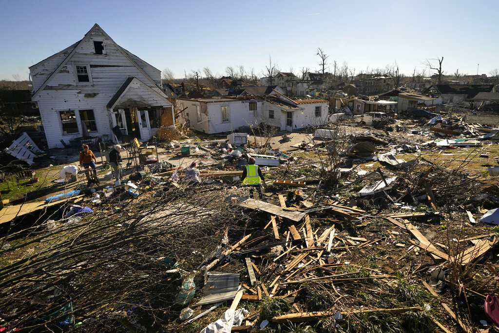 Voluteers help Martha Thomas, second left, salvage possessions from her destroyed home, in the afte...