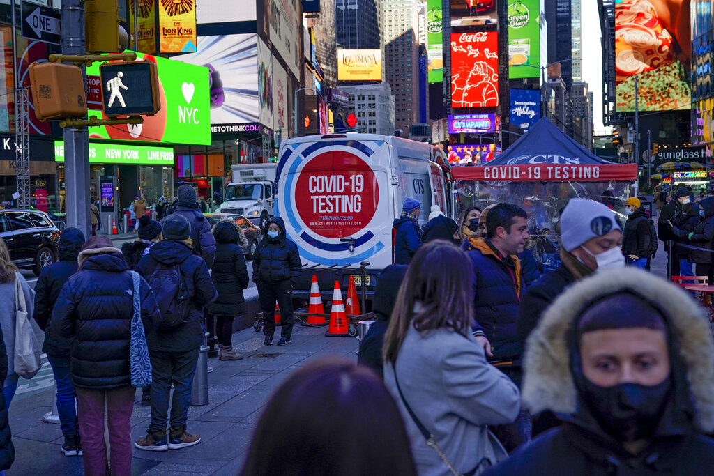 People wait in a long line to get tested for COVID-19 in Times Square, New York, Monday, Dec. 20, 2...