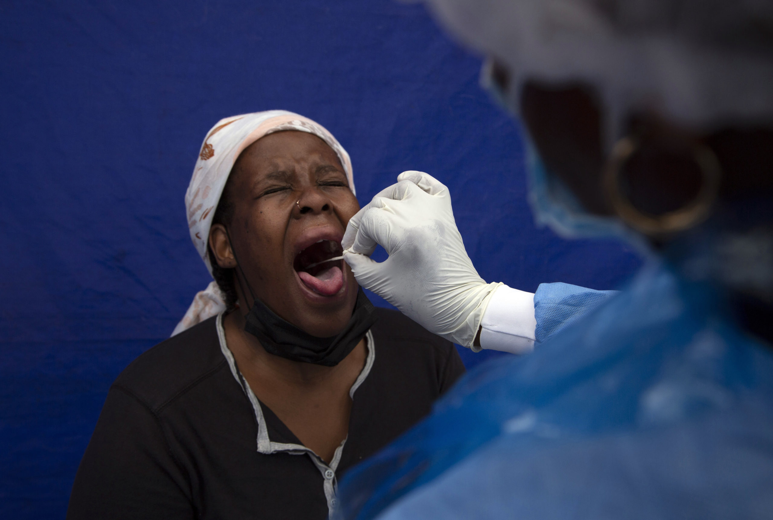 A throat swab is taken from a patient to test for COVID-19 at a facility in Soweto, South Africa, D...