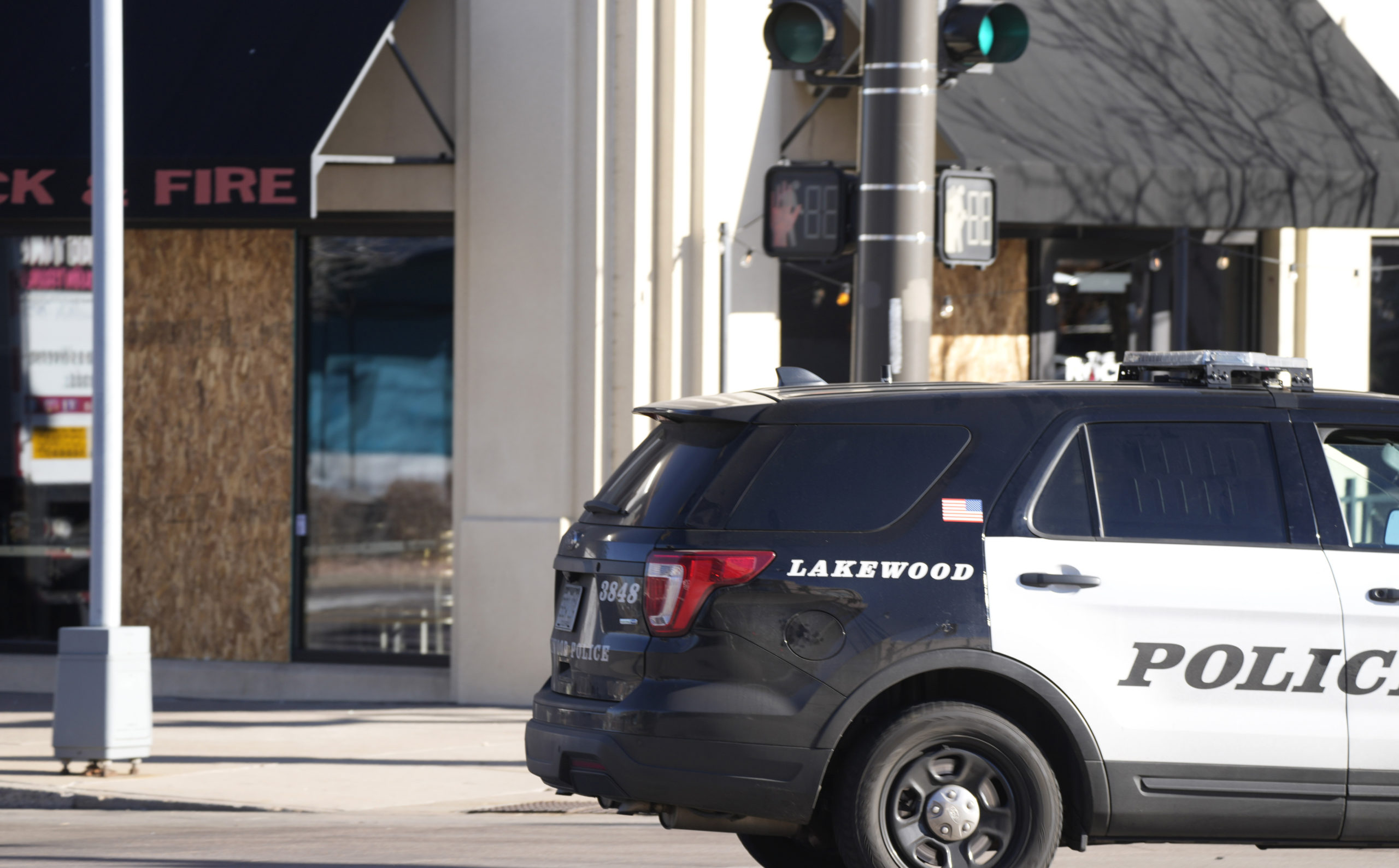 A police vehicle passes through the intersection of Alaska Drive and Vance Street past sheets of pl...