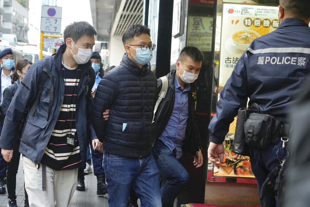 Editor of "Stand News" Patrick Lam, second from left, is arrested by police officers in Hong Kong, ...