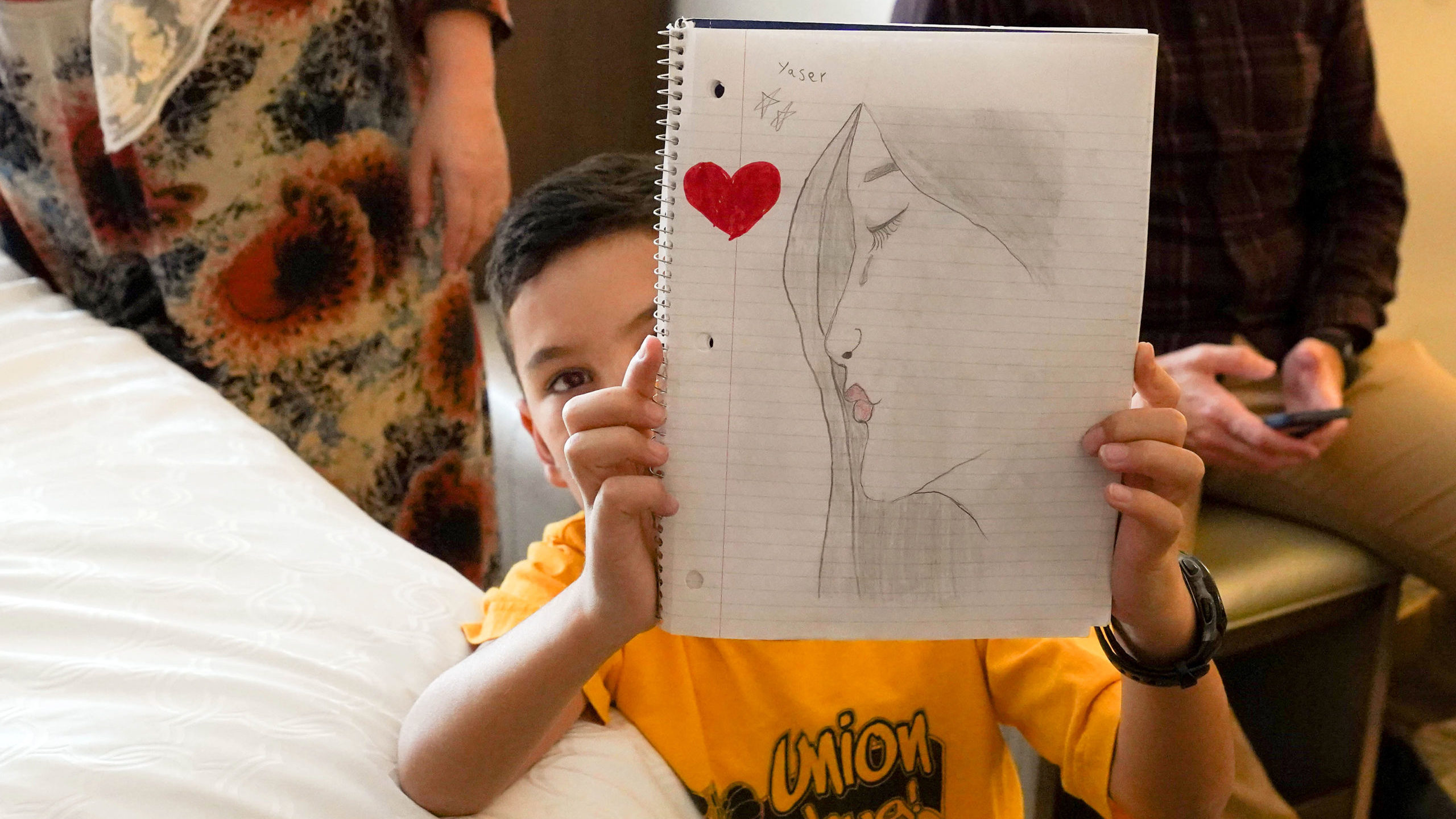 afghan community fund helps refugees arriving in utah - small boy holds drawing...