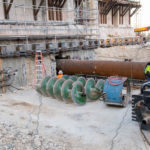 Large pipes are inserted under the existing footings of the building (a process called jack and bore) and the dirt within the pipes is drilled out with a machine using the large green augers during the Temple Square renovation project, Salt Lake City, December 2021.