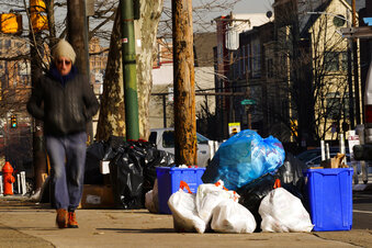 Trash sits out for collection in Philadelphia, Thursday, Jan. 13, 2022. The omicron variant is sick...