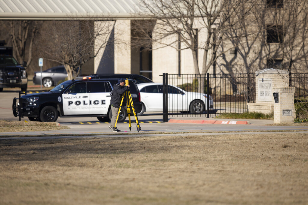 Law enforcement process the scene in front of the Congregation Beth Israel synagogue, Sunday, Jan. ...