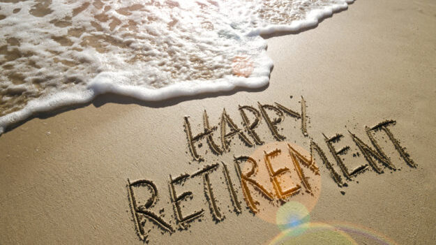Image of the words 'happy retirement' scratched into sand on the beach. A Bankrate survey found hal...