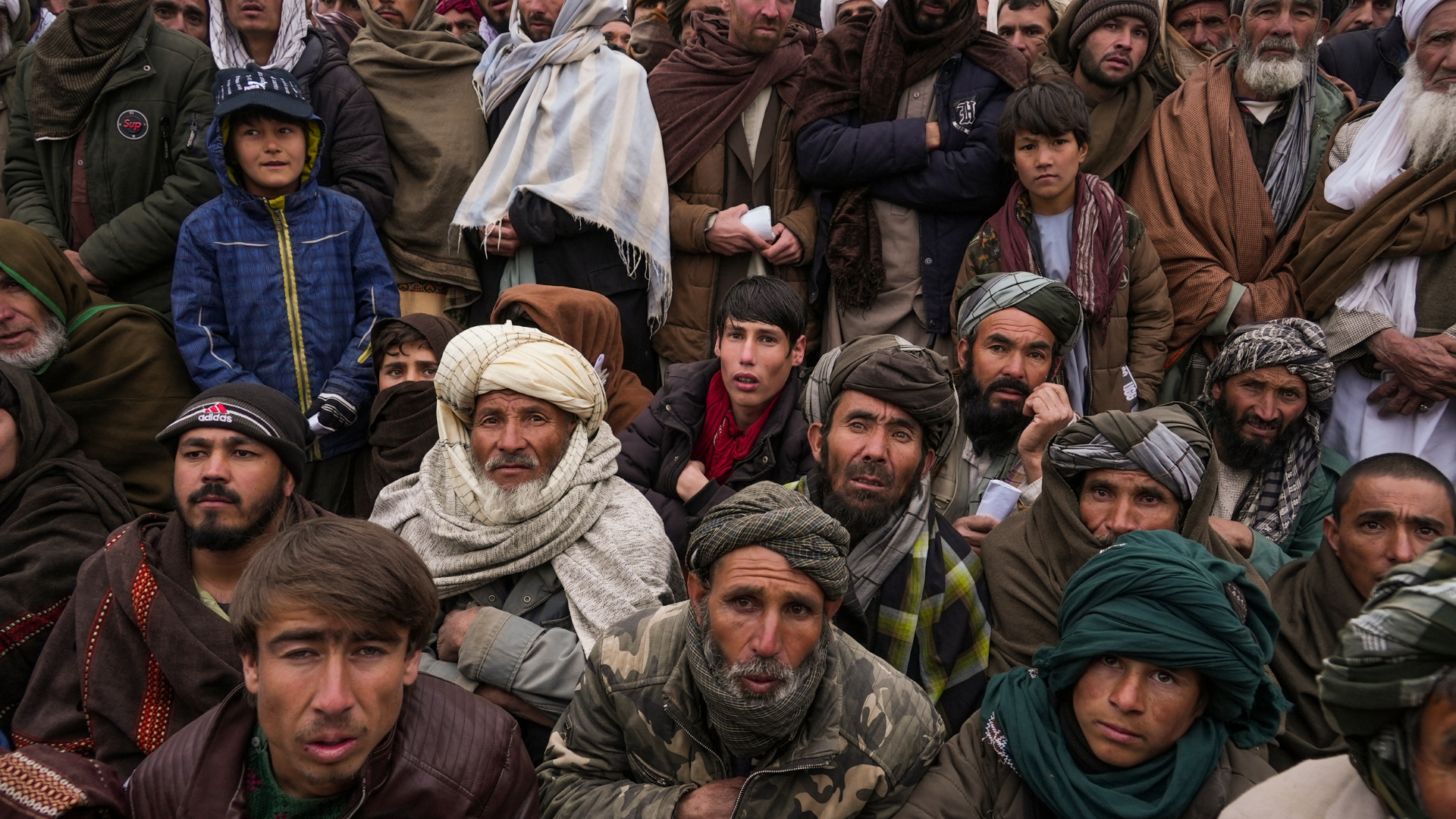 FILE - Hundreds of Afghan men gather to apply for the humanitarian aid in Qala-e-Naw, Afghanistan, ...
