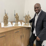 Mauli Junior Bonner inspects miniature mockups of the statues that will be part of the Black pioneer monument being erected at This is the Place Heritage Park. The statues features, Jane Manning James, Green Flake, Hark Wales, and Oscar Smith. Photo Credit: Mauli Bonner. 