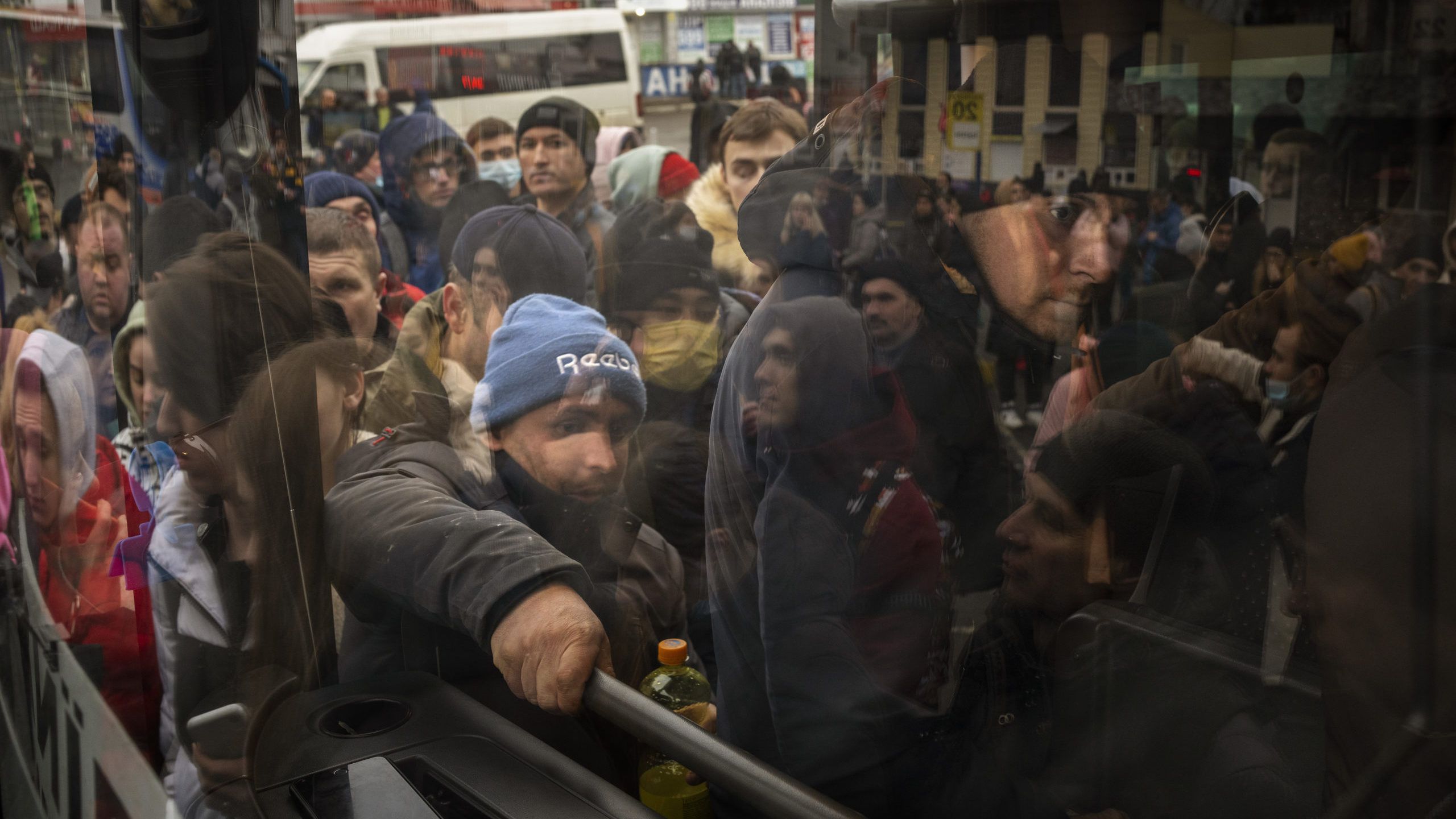 People try to get on a bus as they leave Kyiv, Ukraine, Thursday, Feb. 24, 2022. Russia launched a ...