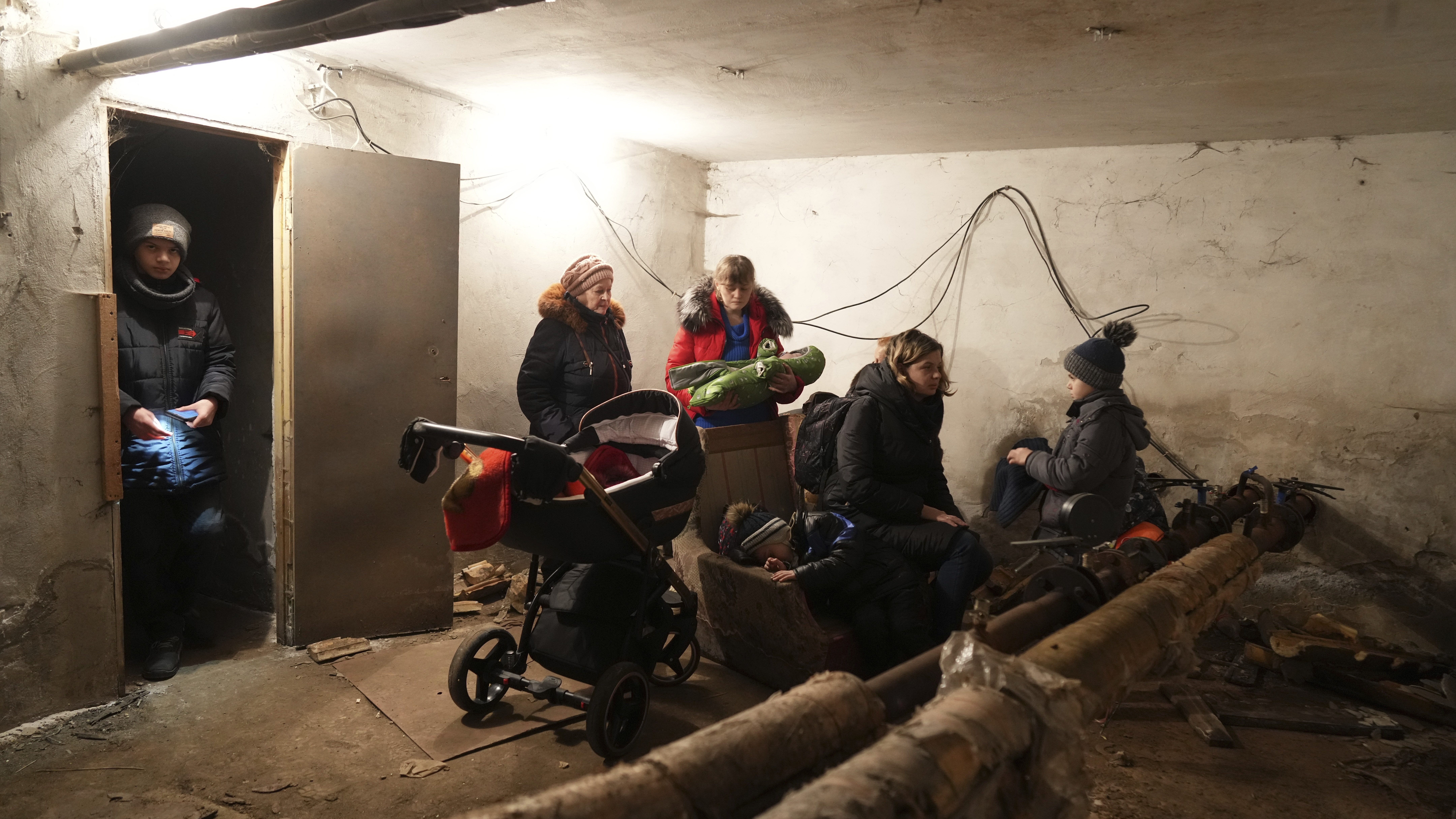 People gather in a shelter during Russian shelling, in Mariupol, Ukraine, Thursday, Feb. 24, 2022. ...