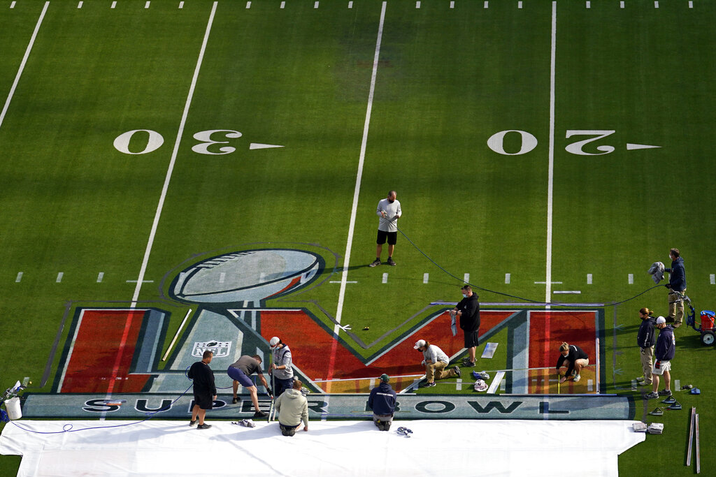 Workers paint a logo on the field at SoFi Stadium days before the Super Bowl on Tuesday, Feb. 8, 20...
