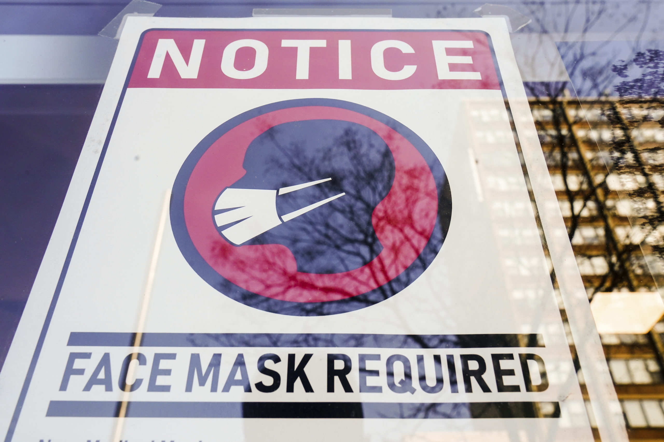 FILE - A sign requiring masks as a precaution against the spread of the coronavirus is posted on a ...