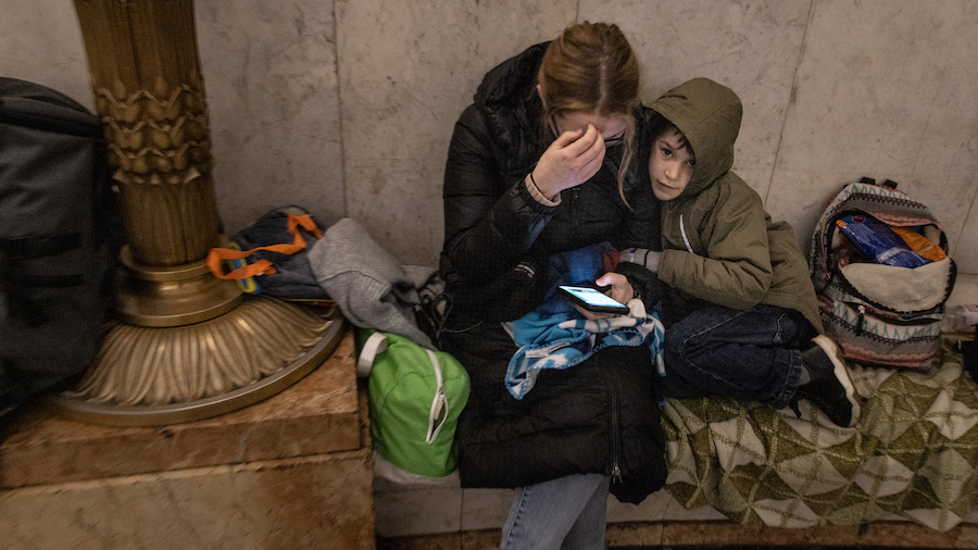 People shelter in a subway station before a curfew comes into effect on February 24, 2022 in Kyiv, ...