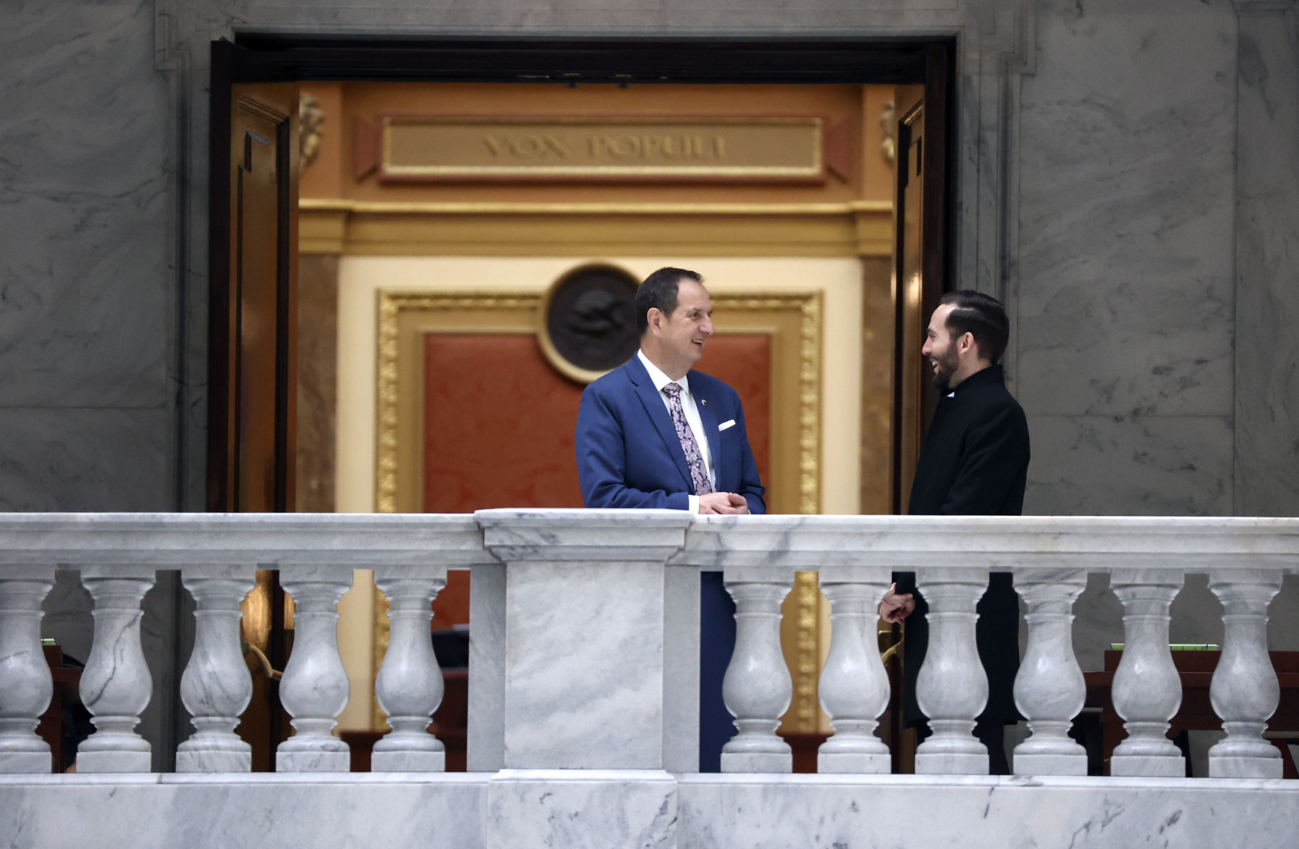 Men talk outside of the House chamber after the morning session of the Utah Legislature at the Capi...