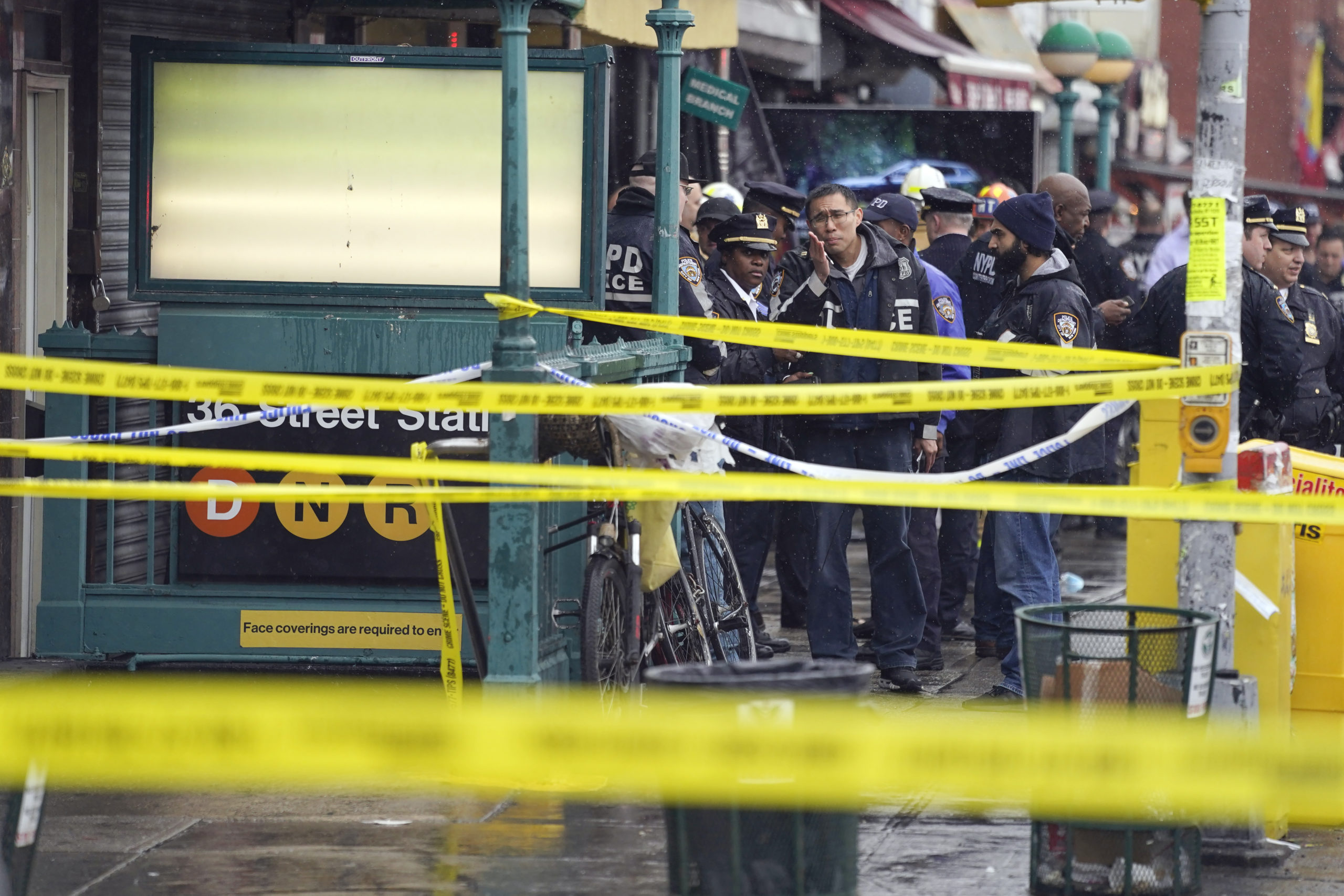 New York City Police Department personnel gather at the entrance to a subway stop in the Brooklyn b...