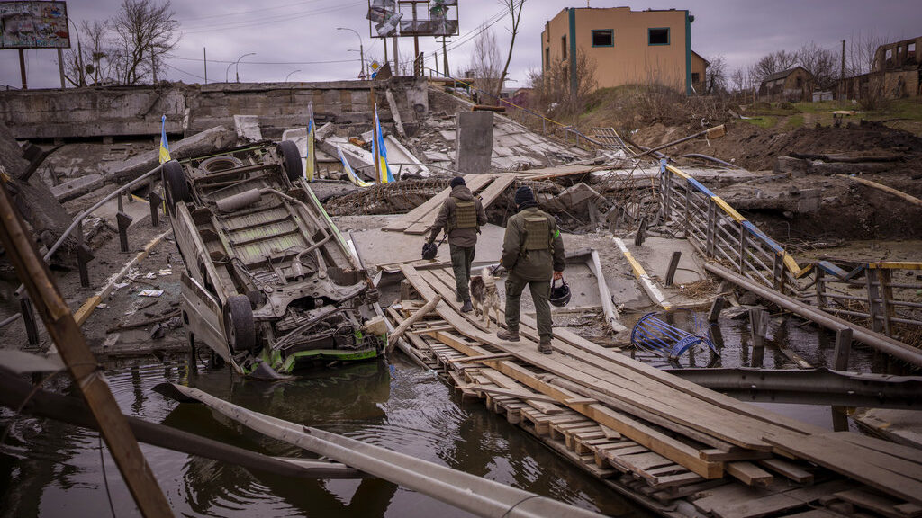 Ukrainian soldiers walk on a destroyed bridge in Irpin, on the outskirts of Kyiv, on Wednesday, Apr...