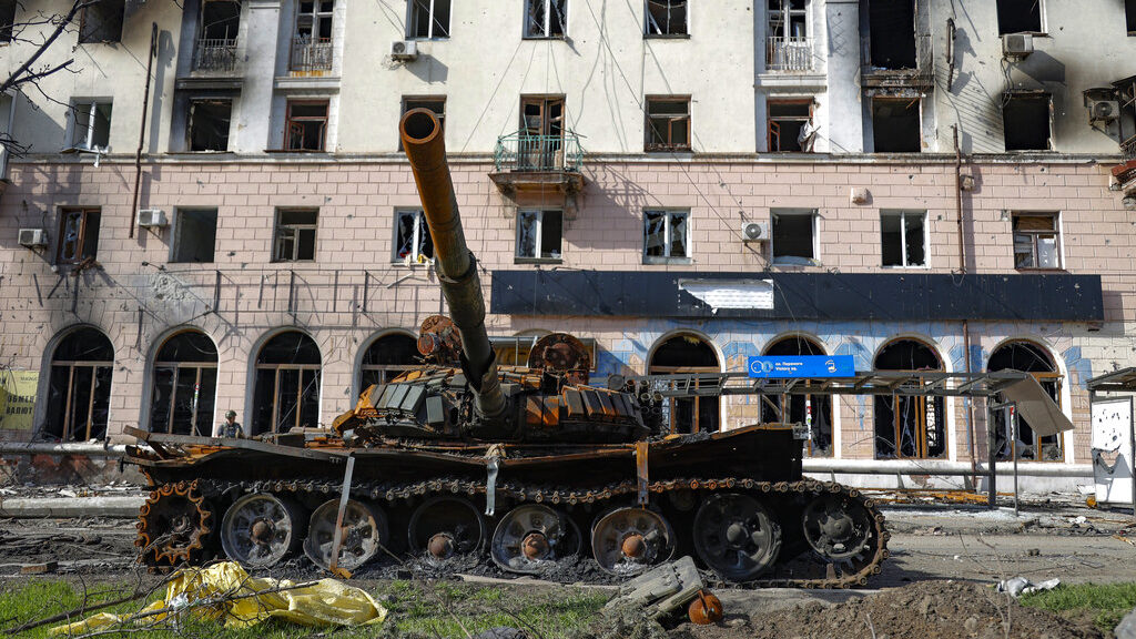 A destroyed tank and a damaged apartment building from heavy fighting are seen in an area controlle...