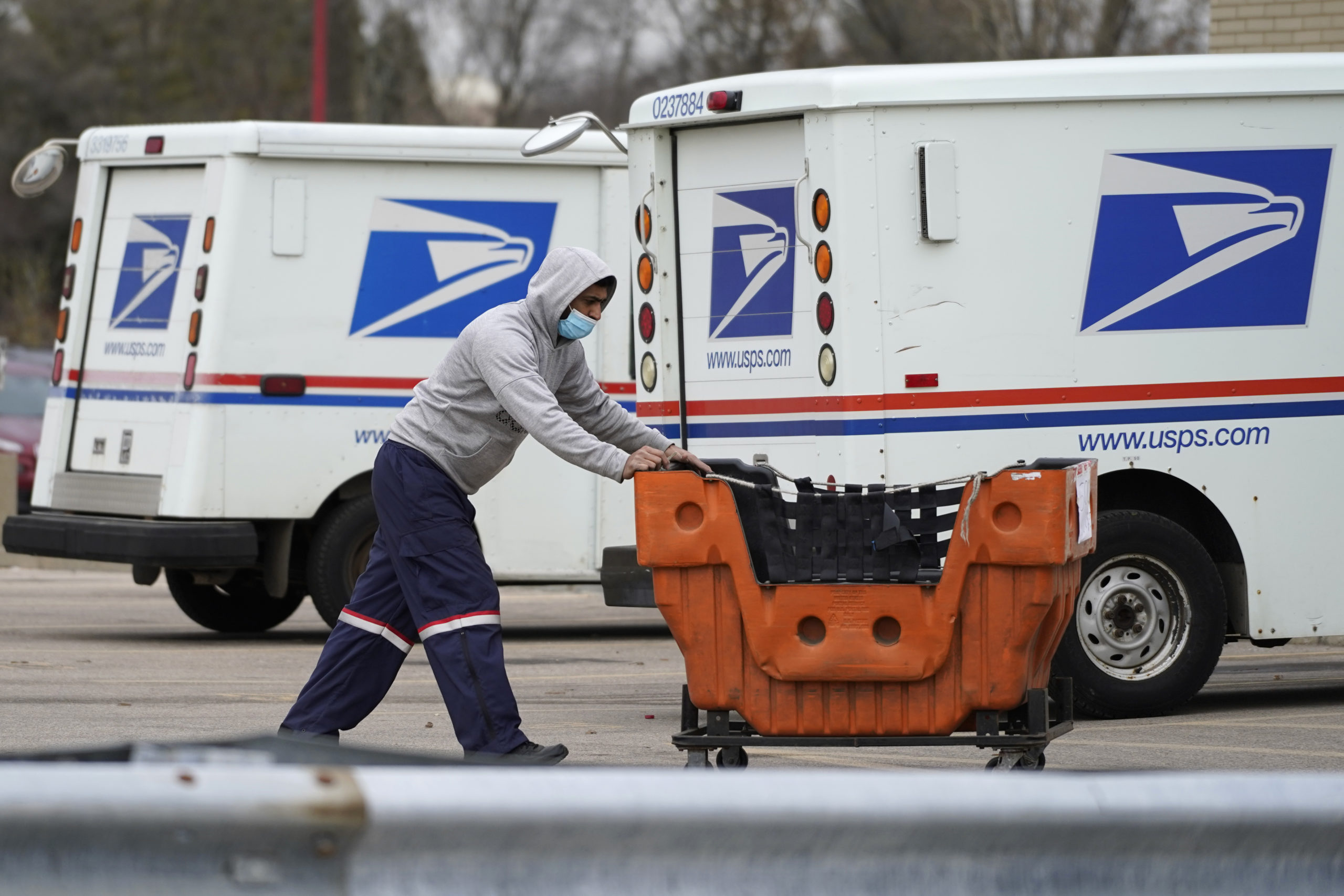 FILE - A United States Postal Service employee works outside a post office in Wheeling, Ill., Dec. ...