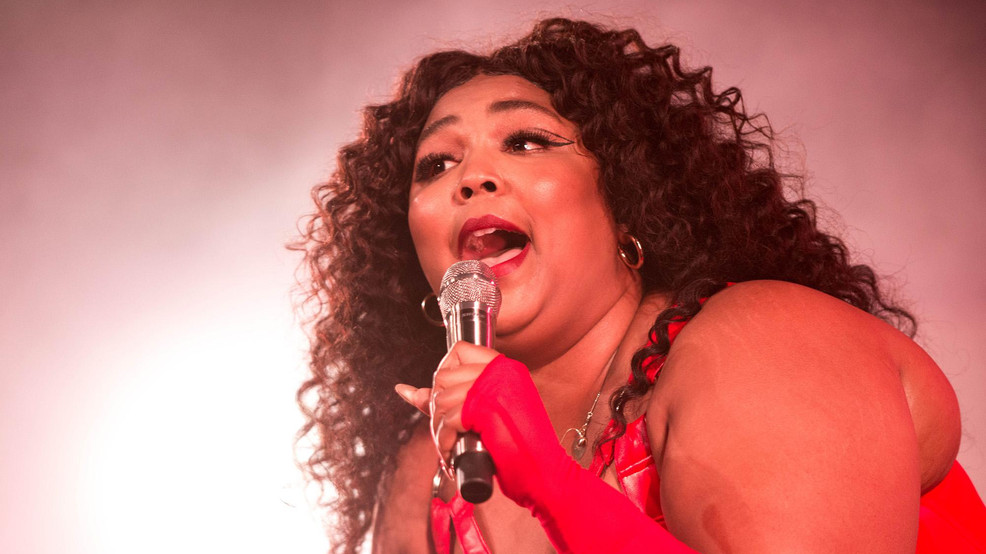 Photo of Lizzo singing in microphone...