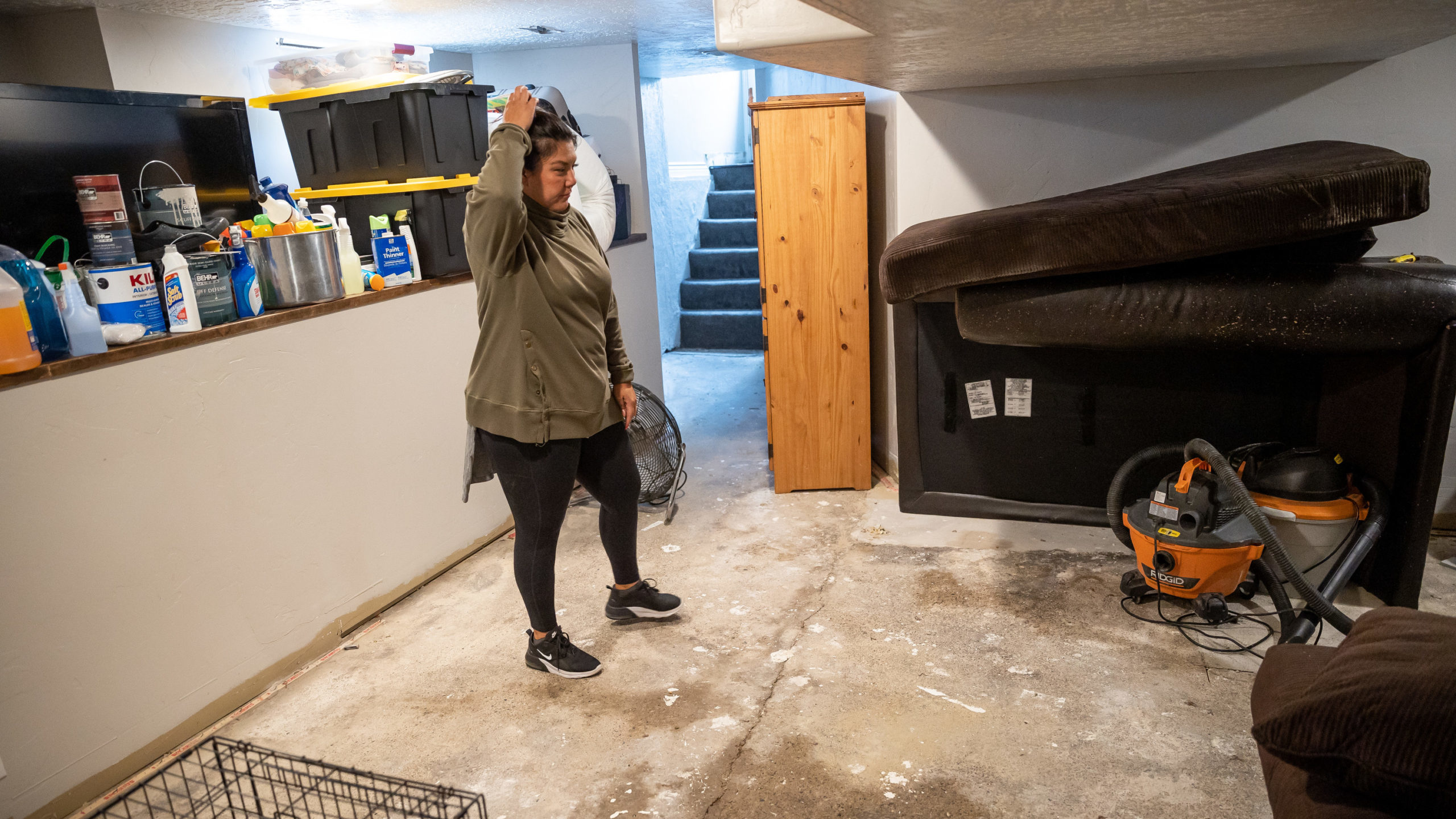 A woman looks at her flooded basement....