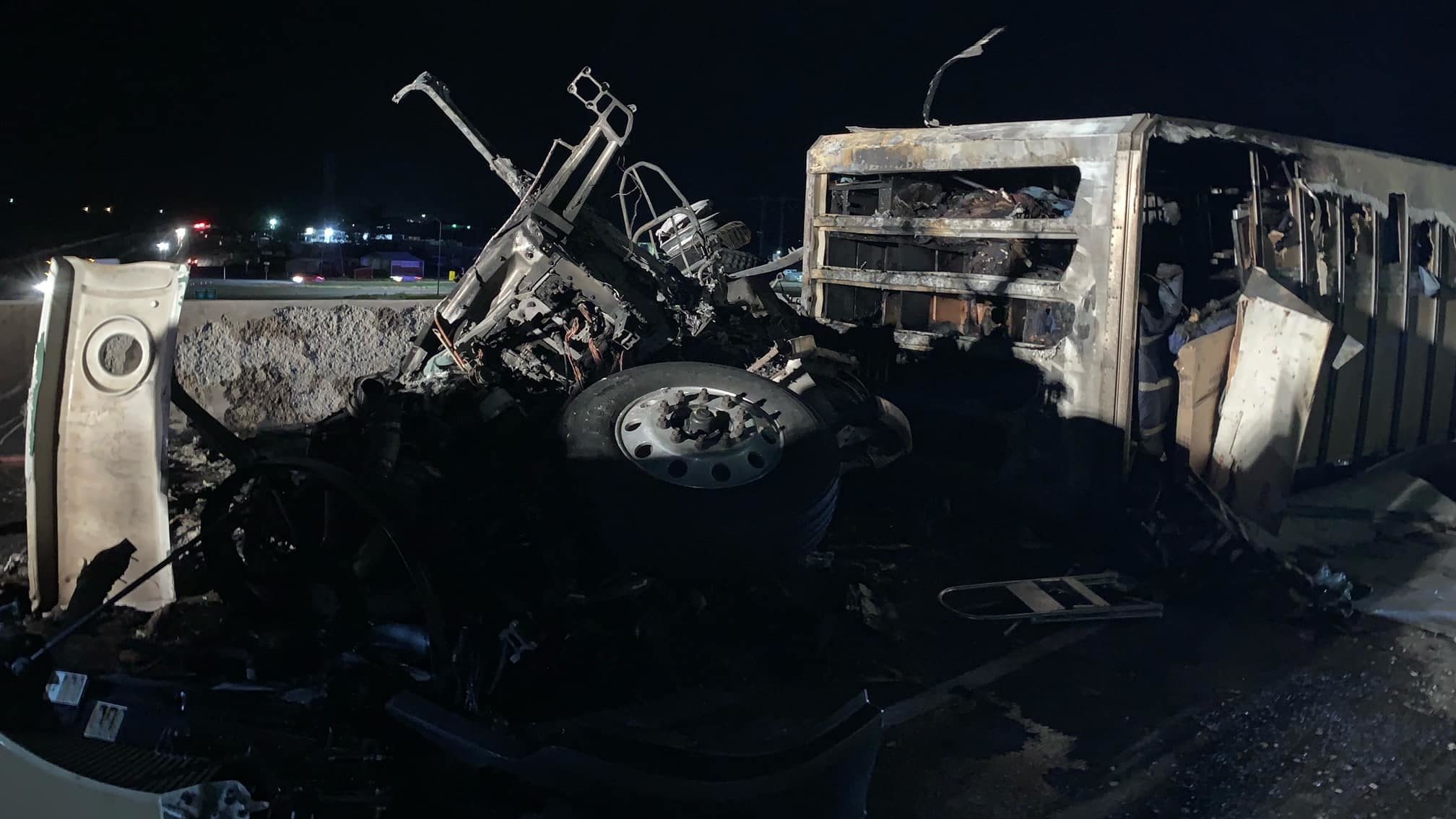 Image of a burned down trailer with blackened car parts...