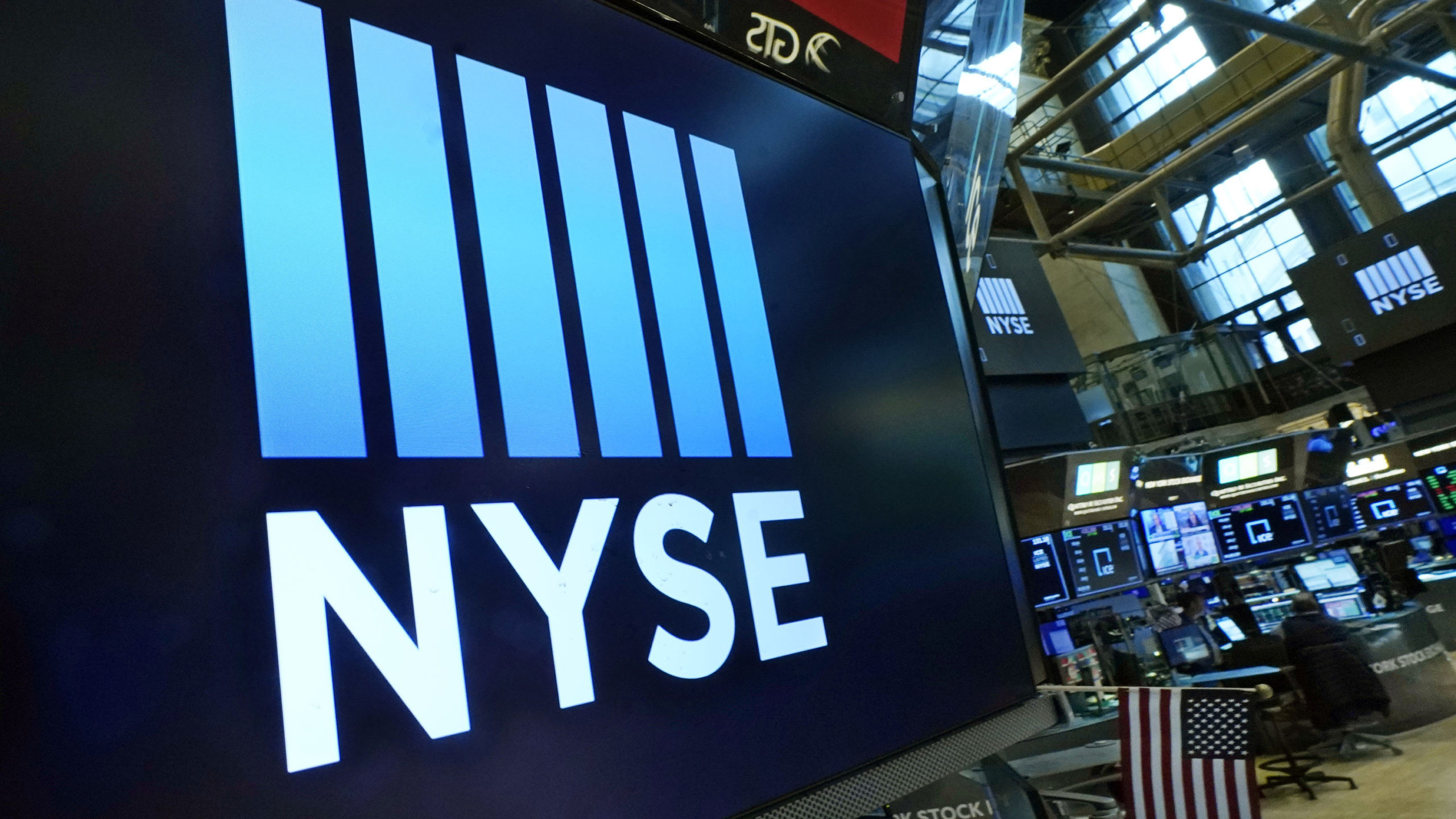 FILE - The New York Stock Exchange logo adorn trading posts, on the floor, Wednesday, March 16, 202...