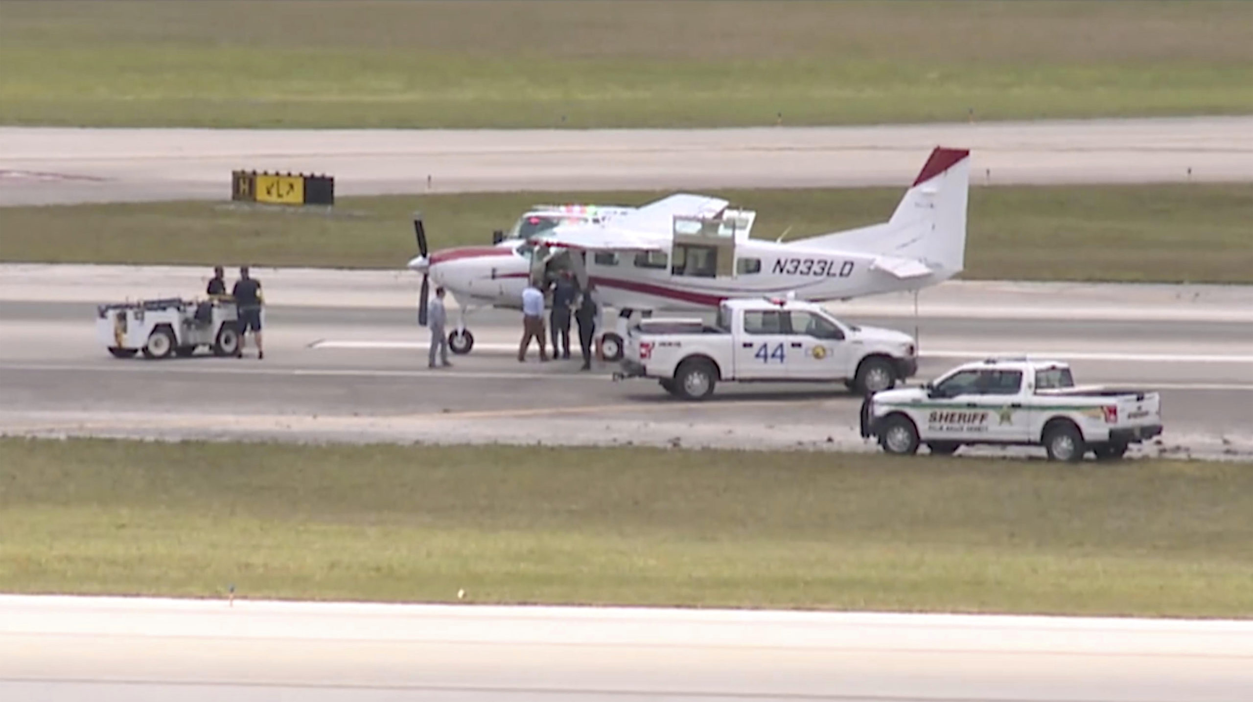 In this still image from video by WPTV shows emergency personnel surrounding a Cessna plane at Palm...
