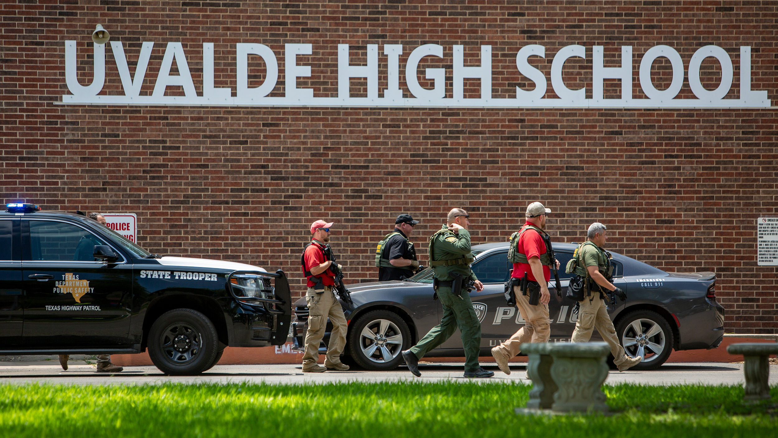 Law enforcement personnel walk outside Uvalde High School after shooting a was reported earlier in ...