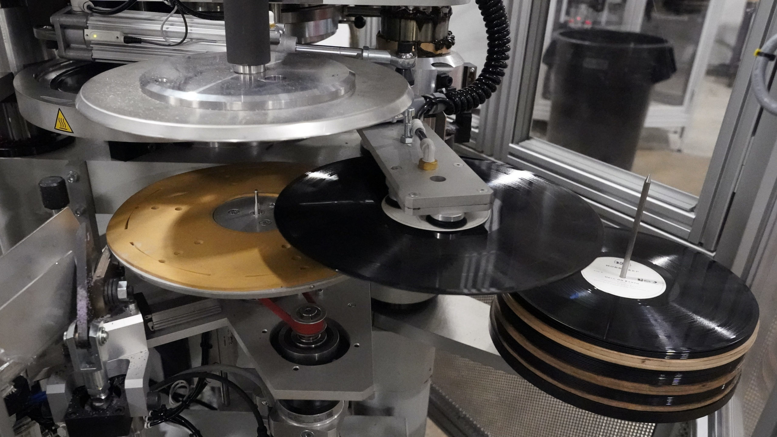 Freshly pressed vinyl records are produced in a stamper at the United Record Pressing facility Thur...