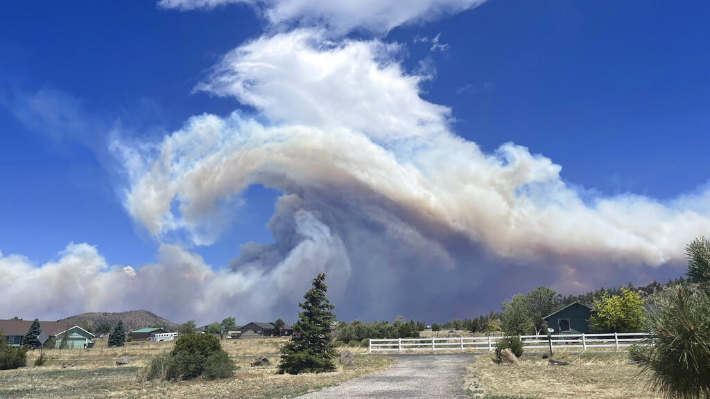 This Monday, June 13, 2022, photo provided by Krissie Maxwell shows smoke from a wildfire on the ou...