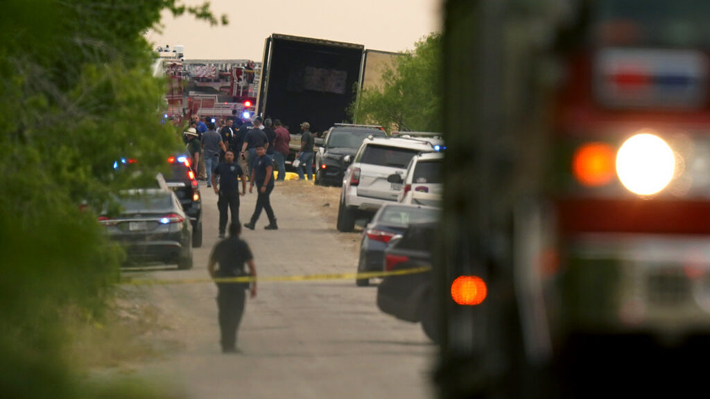 Body bags lie at the scene where a tractor trailer with multiple dead bodies was discovered, Monday...