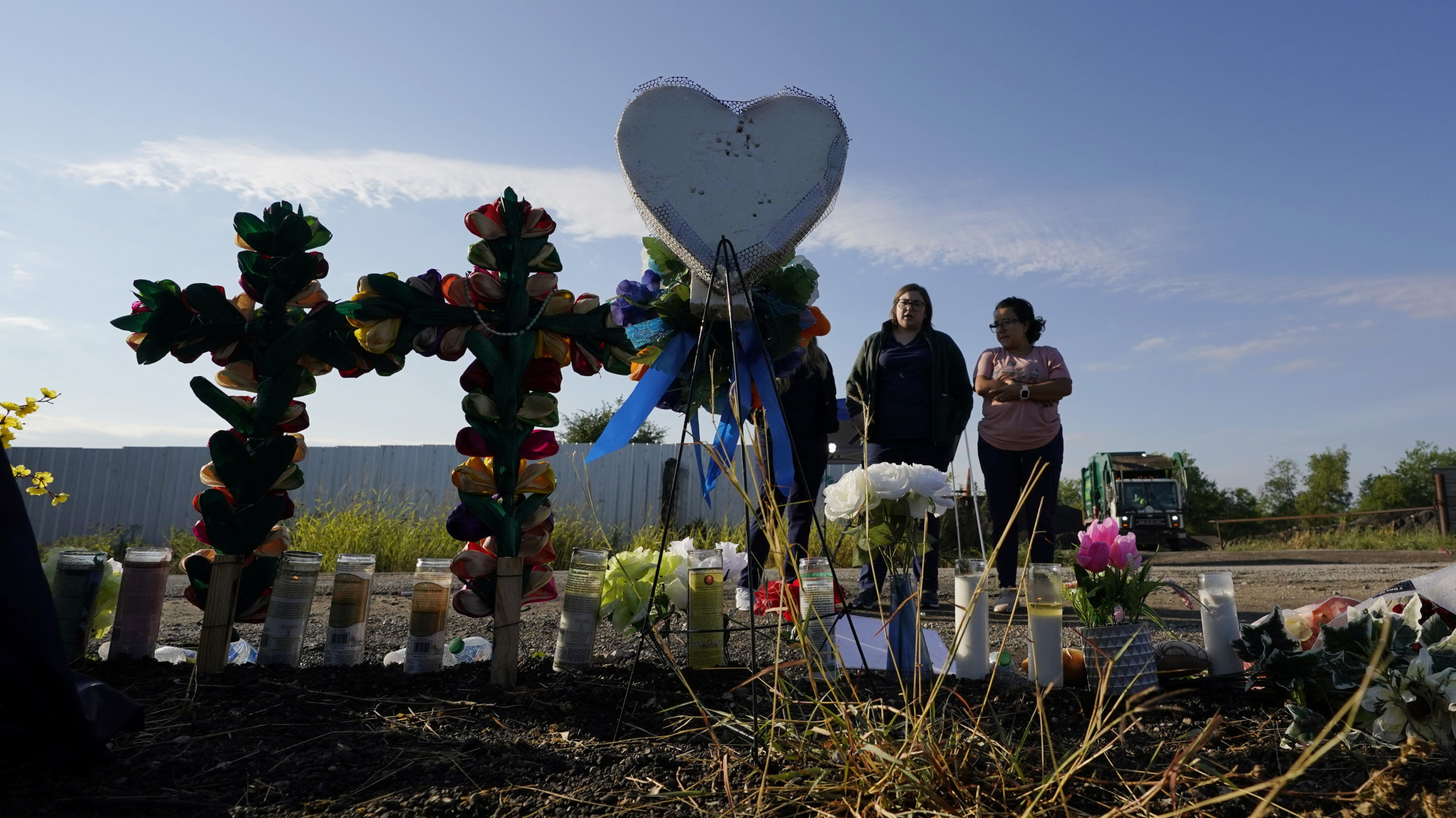 Mourners pay their respects at a makeshift memorial at the site where officials found dozens of peo...