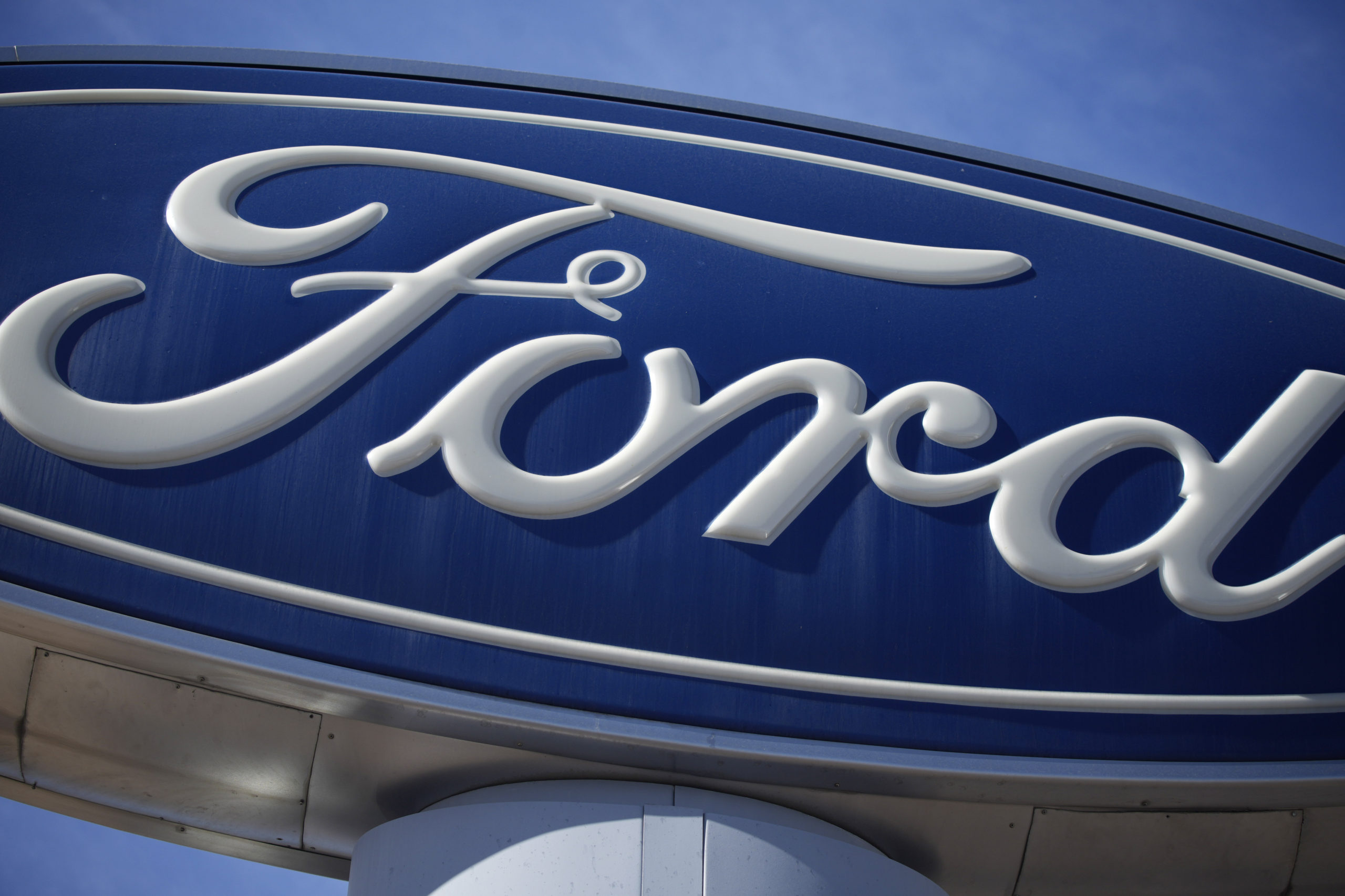 FILE - This Oct. 24, 2021 file photo shows a Ford company logo on a sign at a Ford dealership in so...