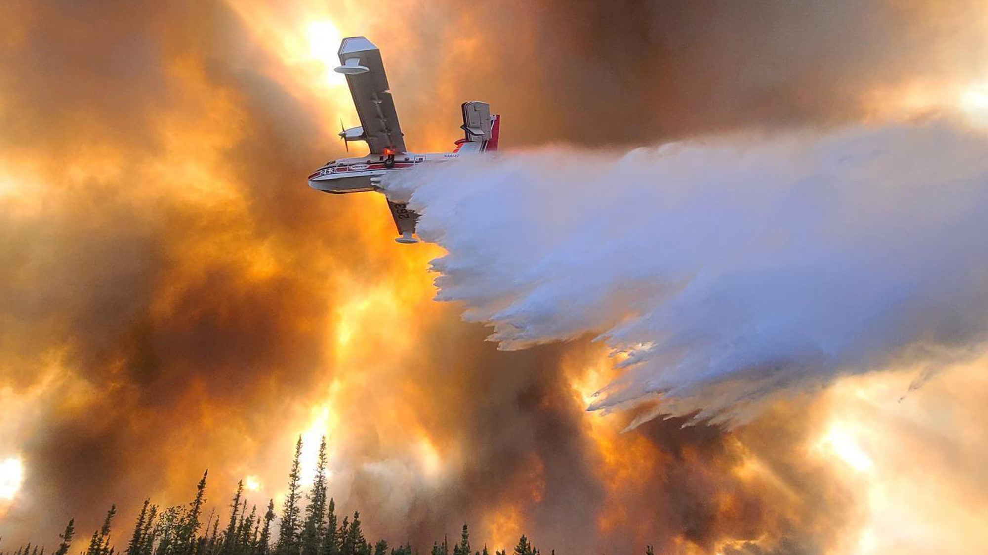 Fire fighting plane above forest fire in Alaska...