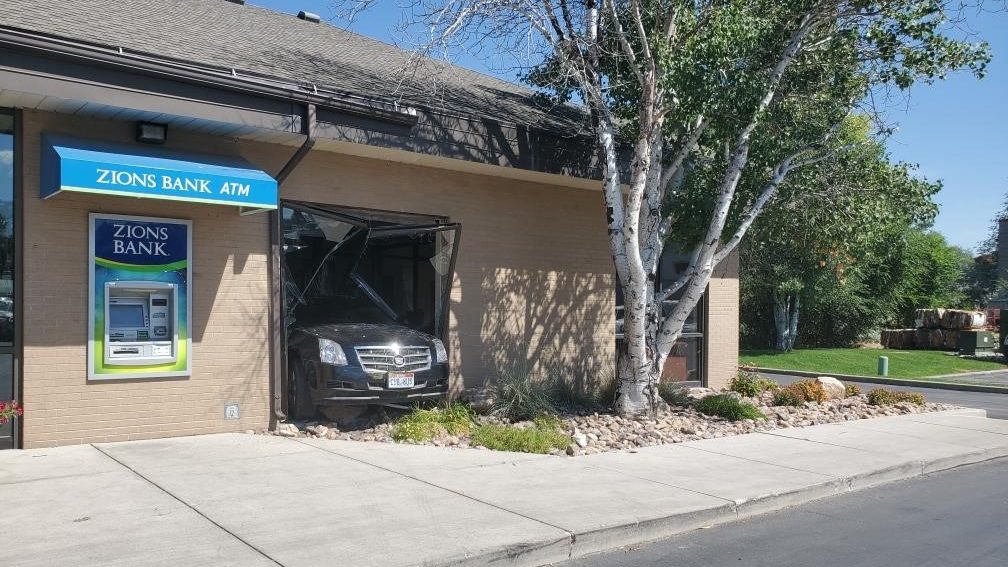 Image of a vehicle halfway inside of a bank building...
