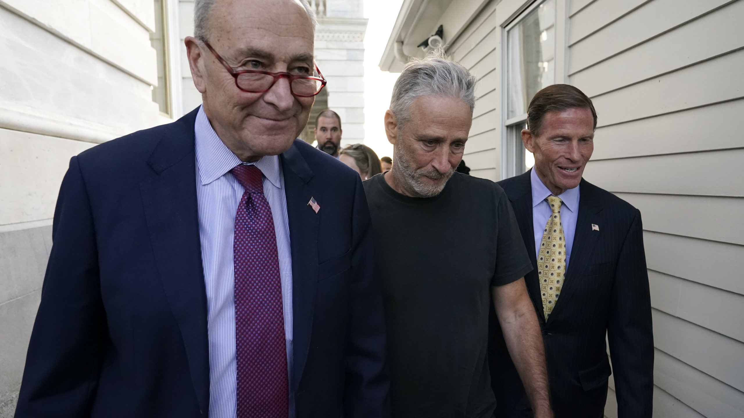 Jon Steward, center, walks with Senate Majority Leader Chuck Schumer of N.Y., left, and Sen. Richar...