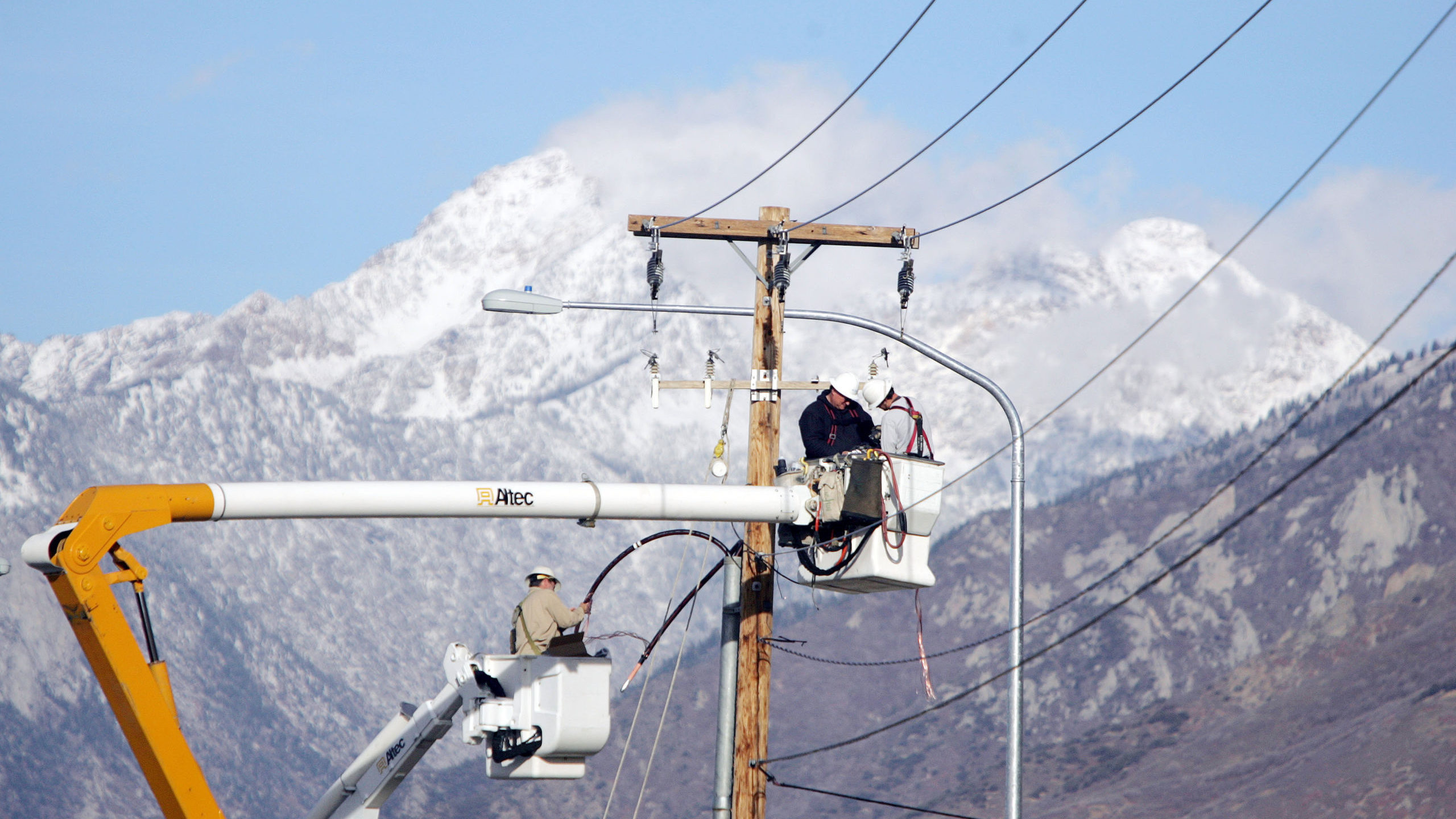 A man works on a power pole, RMP just reported a power outage in salt lake city...