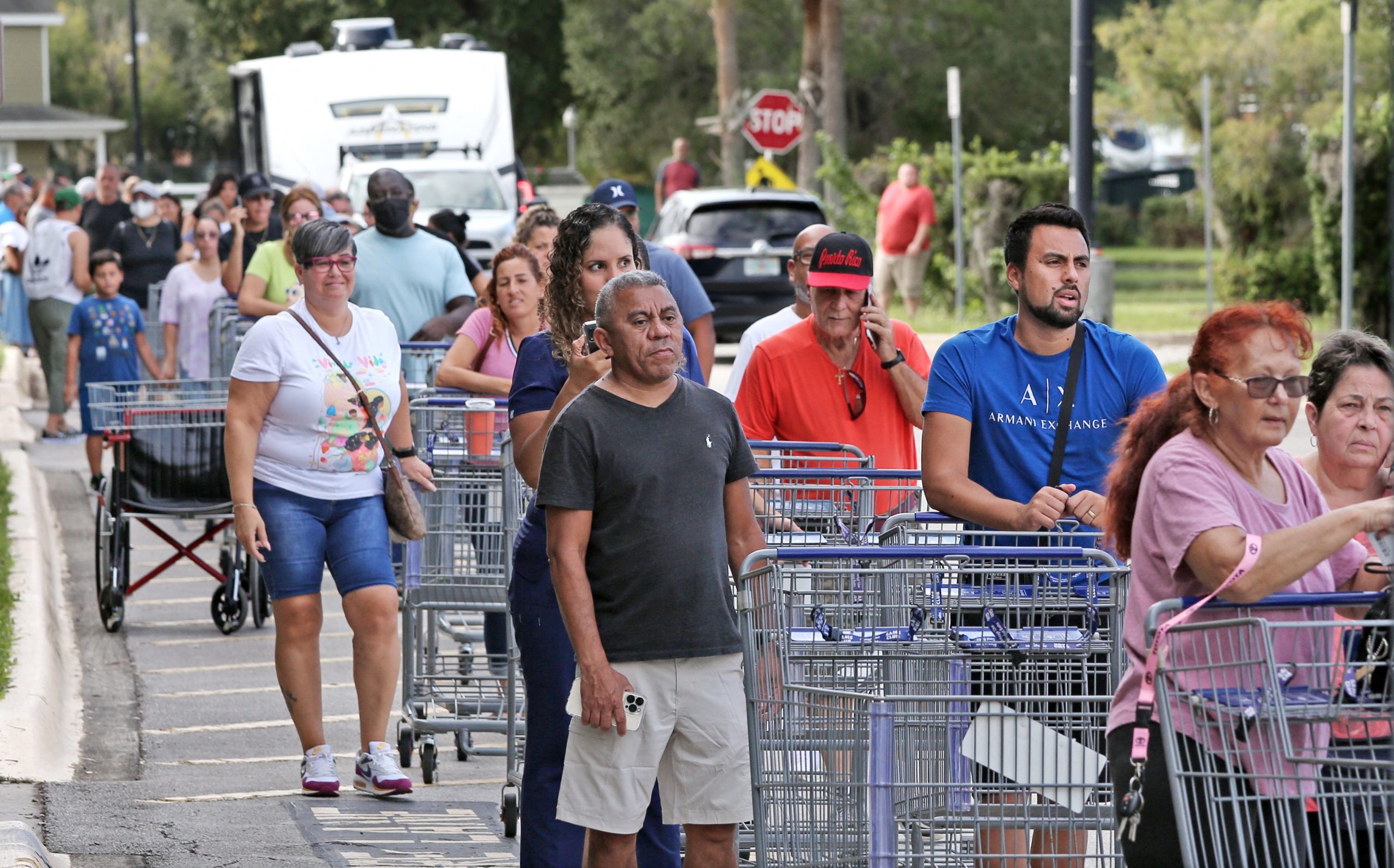 Shoppers wait in line outside a retail warehouse as people rush to prepare for Tropical Storm Ian, ...