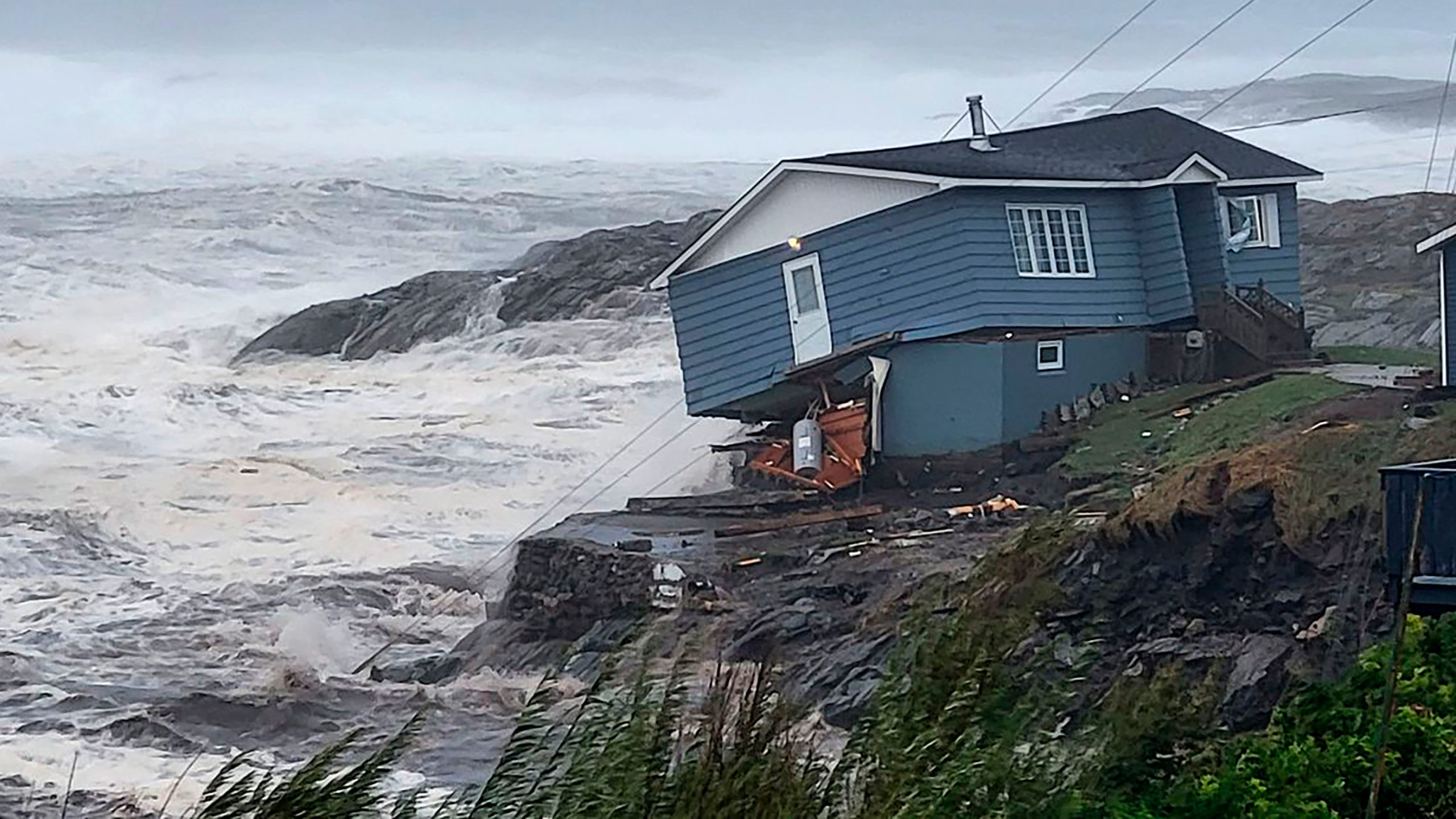 In this photo provided by Wreckhouse Press a home fights against high winds caused by post Tropical...