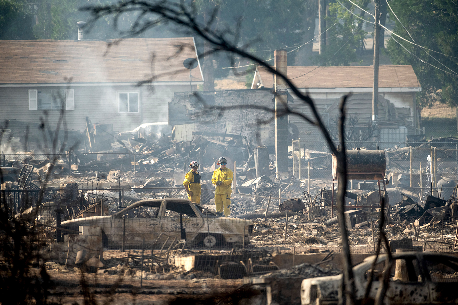 Firefighters survey homes on Wakefield Avenue destroyed by the Mill Fire on Saturday, Sept. 3, 2022...