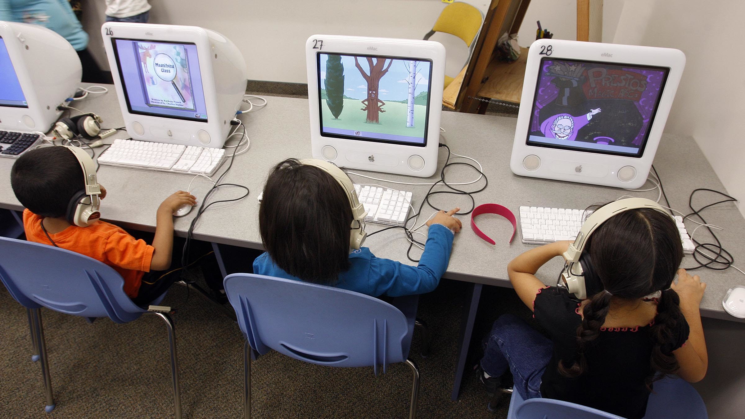 Alpine School District students sit at computers...