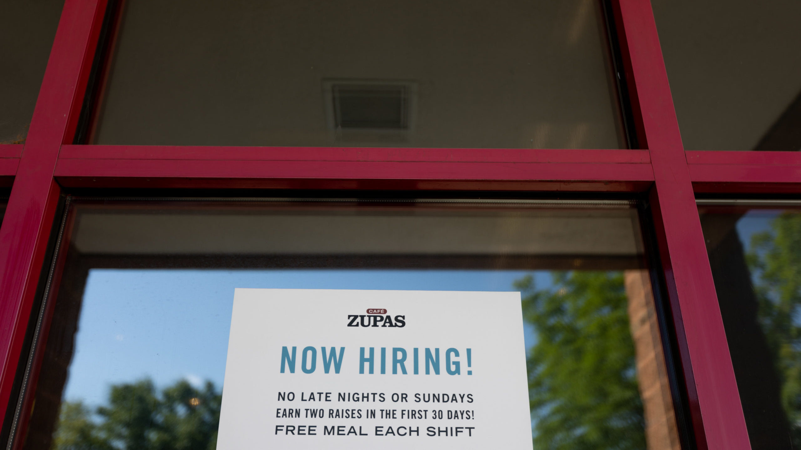 A Now Hiring sign hangs in the window of Zupas in Salt Lake City on Wednesday, July 20, 2022. (Ben ...